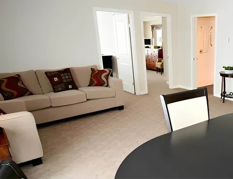 Sitting area with sofas beside a dining table and open doorways
