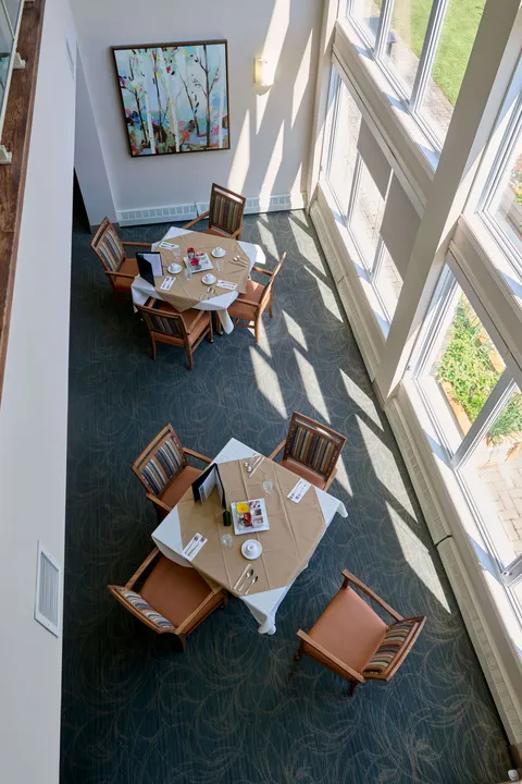 Overhead view of two dining tables beside tall windows
