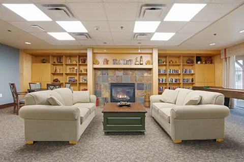 Lounge with sofas, bookshelves and a stone fireplace.