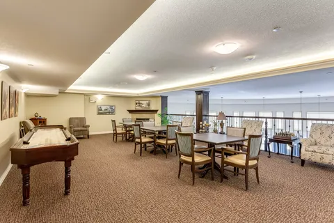Games area with a shuffleboard table, chairs and tables