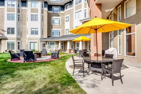 Residence building beside a courtyard with umbrella tables and lawn