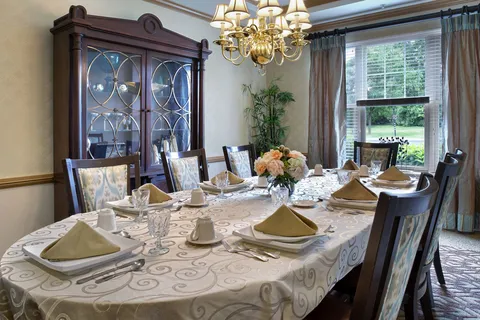 Private dining room with a set table, wooden chairs and a glass-fronted cabinet.