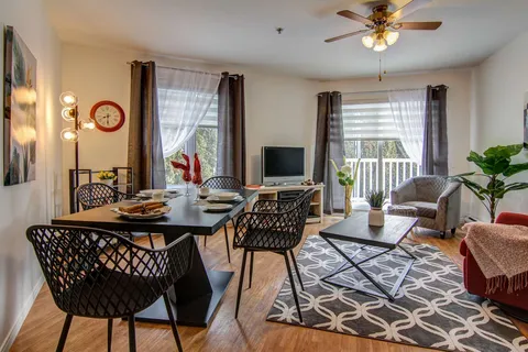 Suite living and dining room beside large windows.