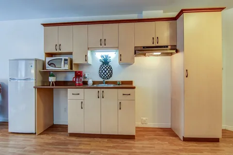 Kitchenette with a microwave and wooden cupboards.