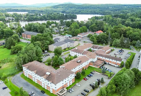 Aerial view of a brick building with a driveway and landscaped courtyard