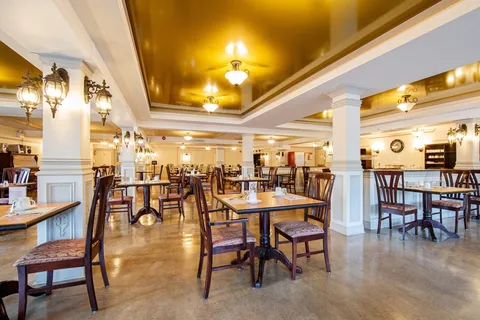 Dining room with round tables, upholstered chairs and ceiling lights