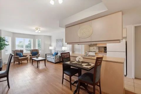 Sitting and dining area with armchairs, a sofa and a kitchen