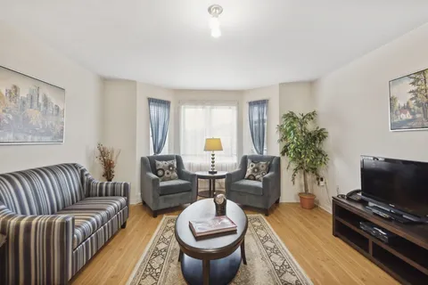 Sitting area with a striped sofa, two armchairs, a television and a coffee table