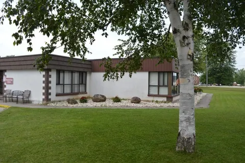 Single-storey residence beside a lawn and leafy birch tree