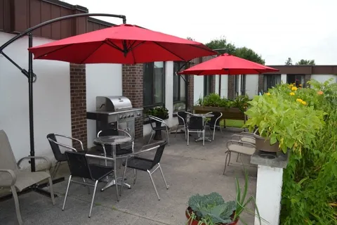 Outdoor tables and chairs beneath red patio umbrellas