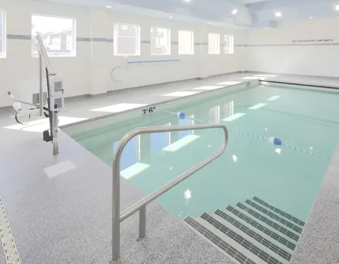 Indoor swimming pool with tiled steps and metal handrails