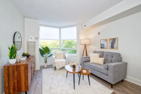 Suite living area with a sofa, armchair and broad window.