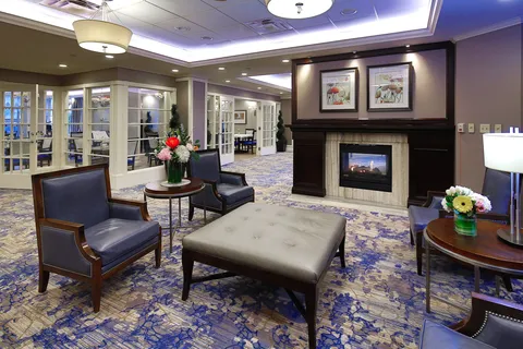 Lounge with armchairs, an ottoman and a fireplace.