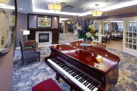 Grand piano beside lounge seating and a fireplace.