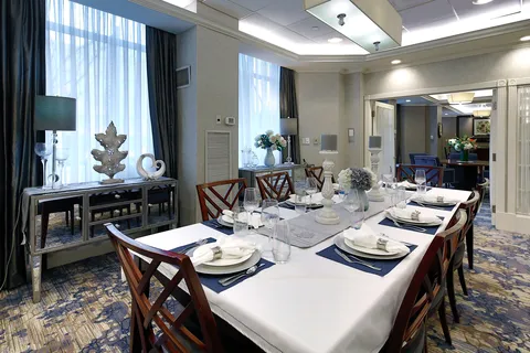 Private dining room with a long set table and large windows.