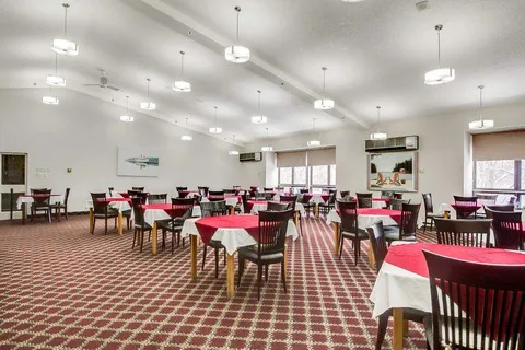 Dining tables with pink cloths beside wide windows