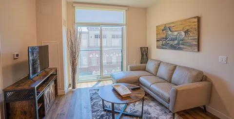 Suite living area with a sofa beside a window.