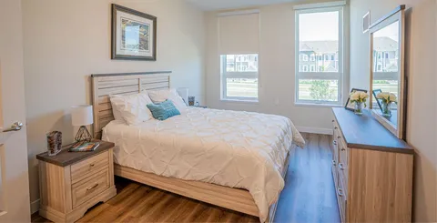 Bedroom with a bed and upholstered seating.