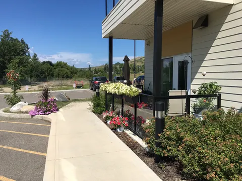 Walkway beside the entrance with flower planters and shrubs.