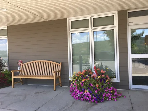 Covered entrance seating with a bench and flower planter.