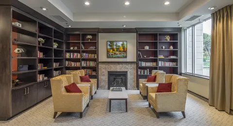 Library with bookshelves, armchairs and round tables