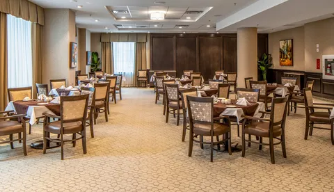 Dining room with set tables, upholstered chairs and large windows