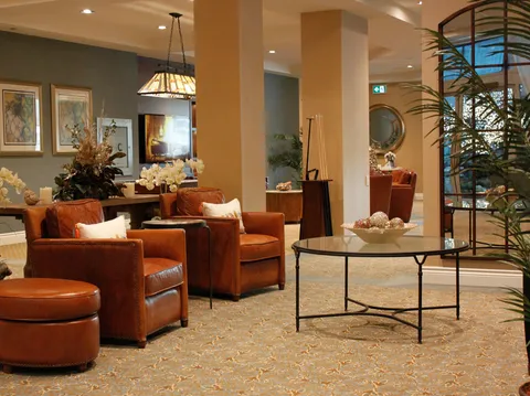 Lounge seating with tables, leather chairs and plants.