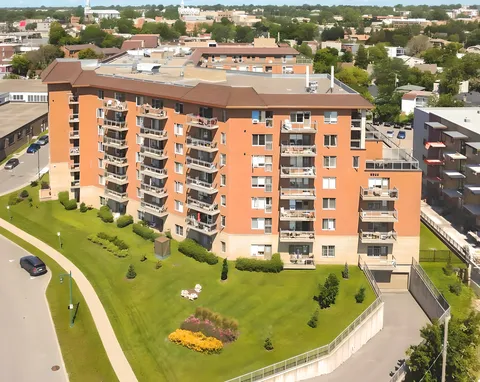 Aerial view of a residence with balconies, lawns, paths and flower beds