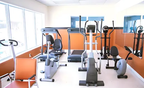 Fitness room with exercise bikes, treadmills, an elliptical machine and mirrors