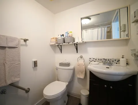 Bathroom with a washbasin, toilet, wall mirror and towels