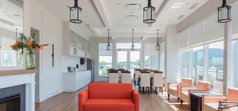 Bright room with orange seating, tables and large windows