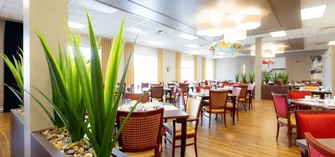 Dining room with tables, red chairs and large windows