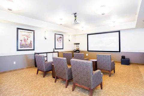 Screening room with armchairs facing a projection screen.