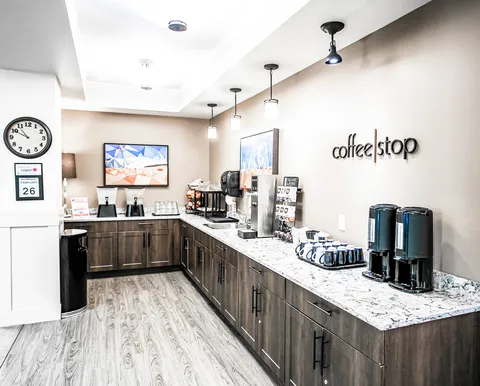 Bistro counter with coffee equipment and white cabinetry.