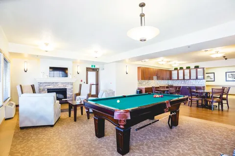Billiards room with a green pool table and seating.