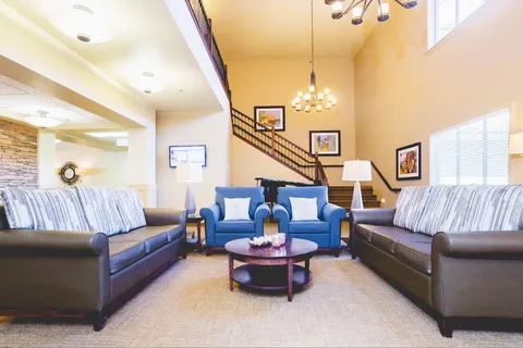 Lounge with sofas, armchairs and large windows.