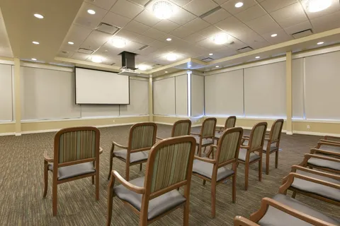 Cinema room with rows of chairs and a projection screen
