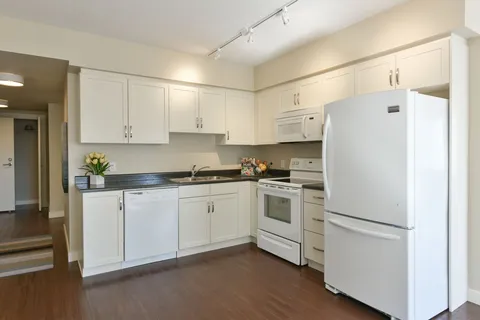 Suite kitchen with white cabinets and appliances