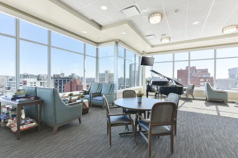 Lounge with a grand piano, tables and corner windows