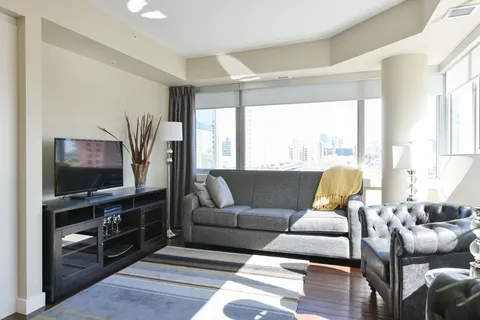 Suite living room with a sofa, television and large windows