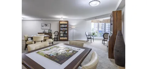 Common room with tables and armchairs beside large windows