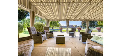 Covered patio with outdoor seating overlooking the garden