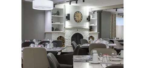 Dining room with set tables beside a fireplace