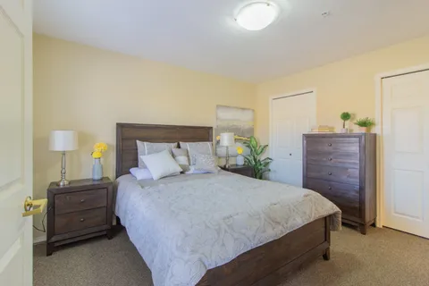 Suite bedroom with a double bed, matching chests and framed pictures.