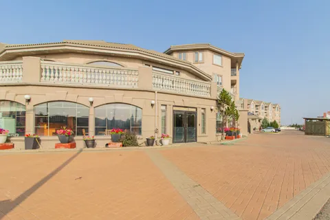 Residence exterior with a curved terrace and paved forecourt.