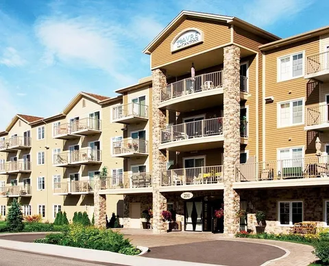 Multi-storey building with balconies, stone columns and a covered entrance
