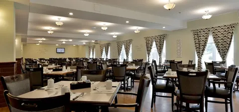 Dining room with tables, chairs and patterned curtains