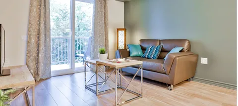 Sitting area with a brown sofa, coffee table and patio door