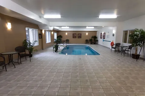 Indoor swimming pool surrounded by a tiled deck.