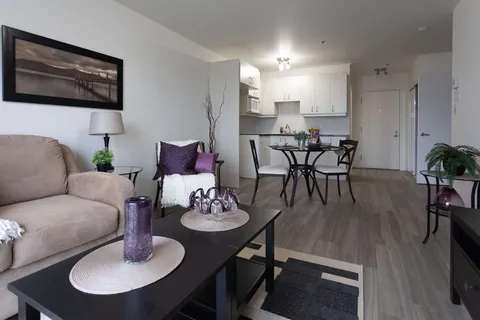 Suite living room with a sofa, dining area and kitchenette.